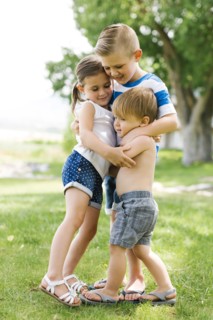 Siblings (2-3, 4-5, 6-7) embracing in park