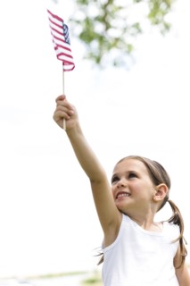 Smiling girl (4-5) holding american flag