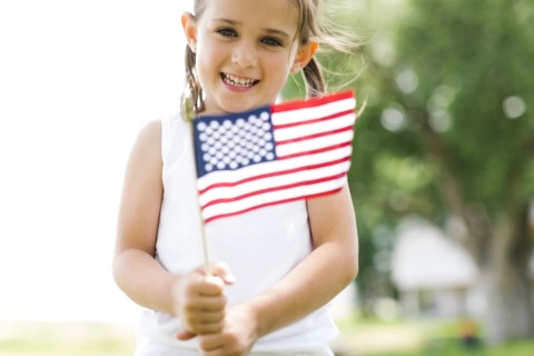 Girl (4-5) holding american flag