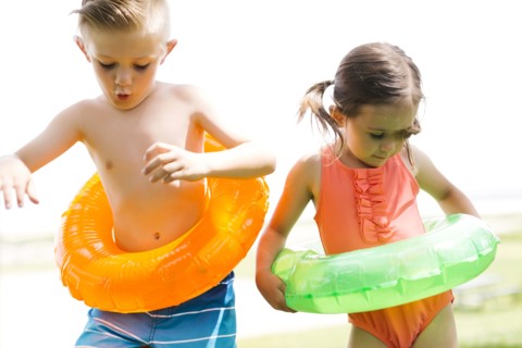 Boy (6-7) and girl (4-5) with inflatable rings