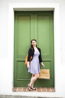Puerto Rico, San Juan, Woman with shopping bag standing in front of green door