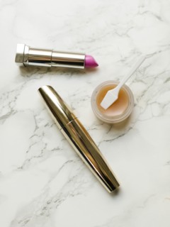 Lipstick and mascara on marble background