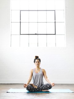 Woman meditating on exercise mat