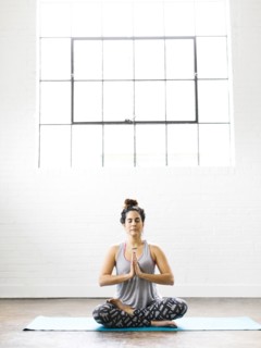 Woman meditating on exercise mat