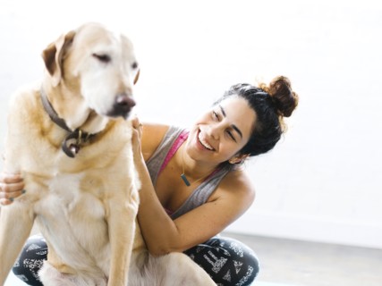 Woman practicing yoga with dog