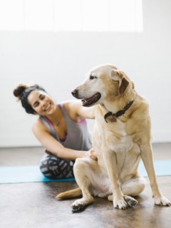 Woman practicing yoga with dog