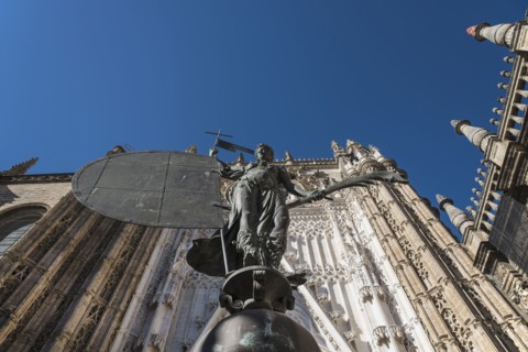 Spain, Seville, Facade of Cathedral of Seville with statue