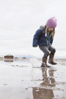 Little girl (4-5) playing in puddle