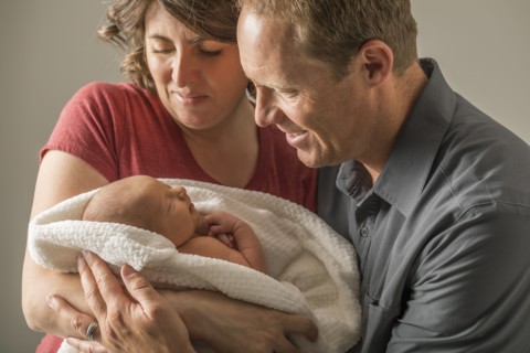 Parents holding and looking at baby son (0-1 months)
