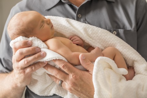 Father embracing newborn son (0-1 month)
