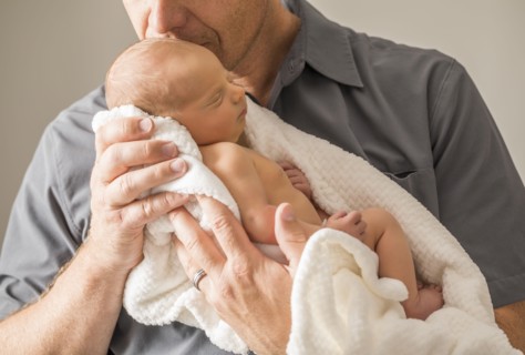 Father embracing newborn son (0-1 month)