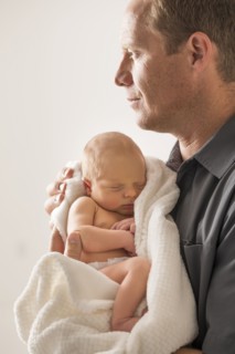 Father embracing newborn son (0-1 month)