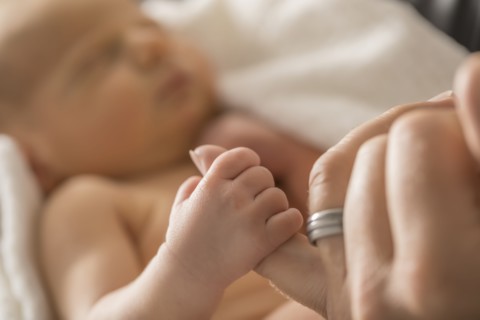 Newborn son (0-1 month) holding father's finger