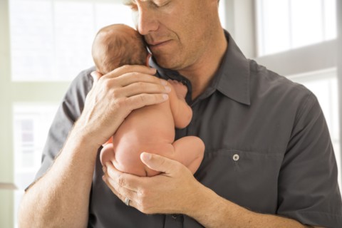 Father embracing newborn son (0-1 month)