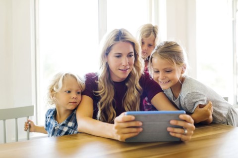 Mother and children (4-5, 6-7, 8-9) with digital tablet
