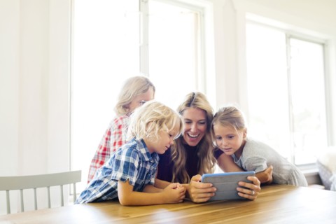 Mother and children (4-5, 6-7, 8-9) with digital tablet