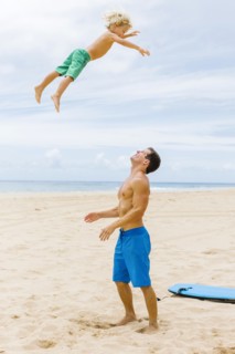 Father with son (4-5) playing at beach