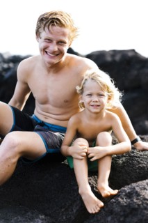 Young man with younger brother (4-5) sitting on rocks