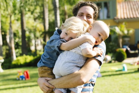 Father with two sons (12-17 months, 4-5) playing in backyard