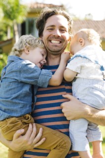 Father with two sons (12-17 months, 4-5) playing in backyard