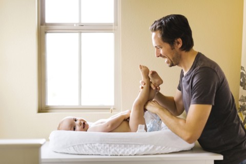 Father changing son's (12-17 months) diaper