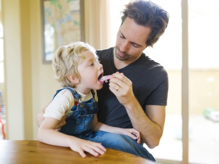 Father giving son (4-5) antibiotic