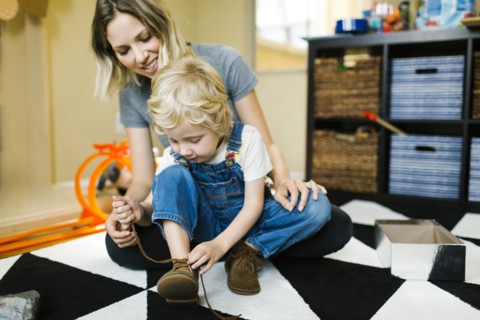 Mother learning son (4-5) to tie shoes
