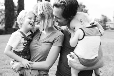 Portrait of parents with sons (12-17 months, 4-5) in park