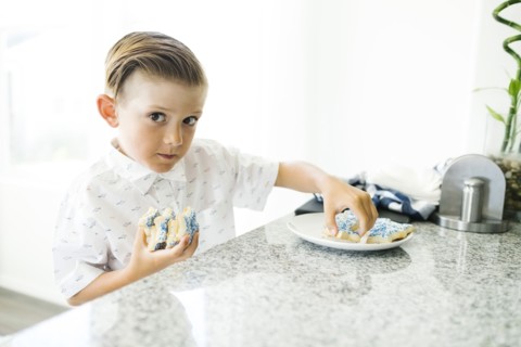 Boy (8-9) stealing cookies