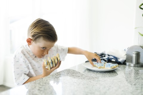 Boy (8-9) stealing cookies