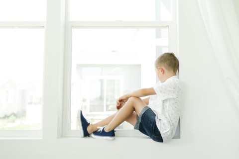 Boy (7-8) looking through window