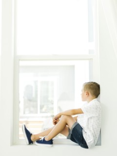 Boy (6-7) looking through window