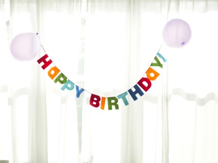 Birthday garland hanging in front of net curtain