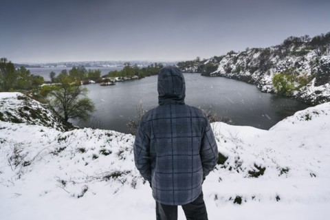 Ukraine, Dnepropetrovsk region, Dnepropetrovsk city, Person looking over winter landscape with lakes