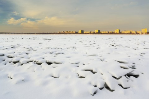 Ukraine, Dnepropetrovsk region, Dnepropetrovsk city, Frozen river with distant cityscape