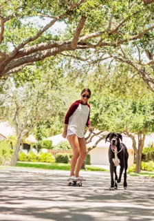 Woman on skate board with Great Dane
