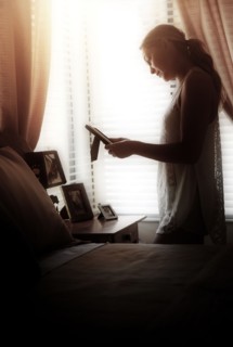 Woman in bedroom looking at photo