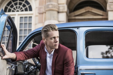 Handsome man disembarking vintage car