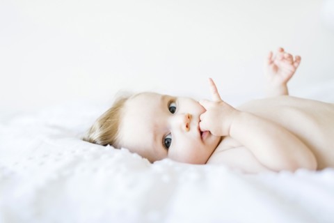 Portrait of baby girl (6-11 Months) with finger in mouth
