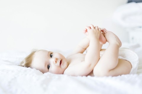 Portrait of baby girl (6-11 Months) looking at camera and smiling