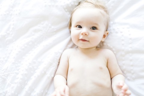 Portrait of baby girl (6-11 Months) smiling, directly above