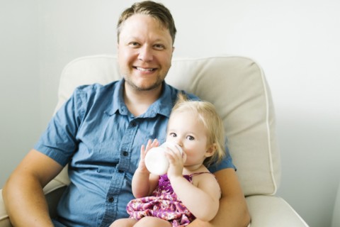 Father feeding baby girl (12-17 months) in living room
