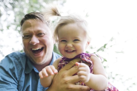 Father playing with baby girl (12-17 months) in backyard
