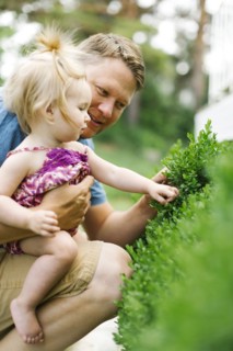 Father playing with baby girl (12-17 months) in backyard