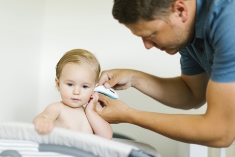 Father measuring temperature to baby girl (12-17 months)