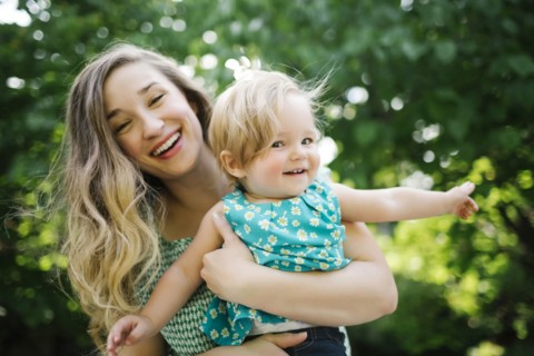 Portrait of mother carrying daughter (12-17 months)