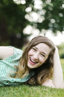 Portrait of woman lying on grass and laughing