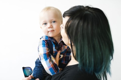 Portrait of mother holding son (12-17 months) against white background