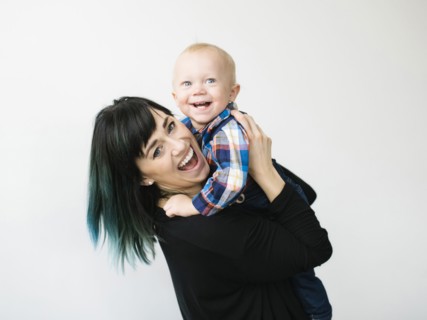 Portrait of mother holding son (12-17 months) against white background