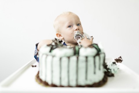 Baby boy (12-17 months) eating birthday cake